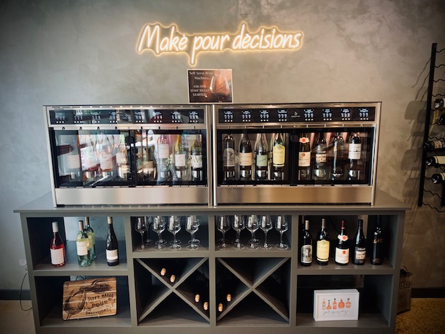 Rosé Boutique self-pour wine machines under the 'Make pour decisions' neon sign